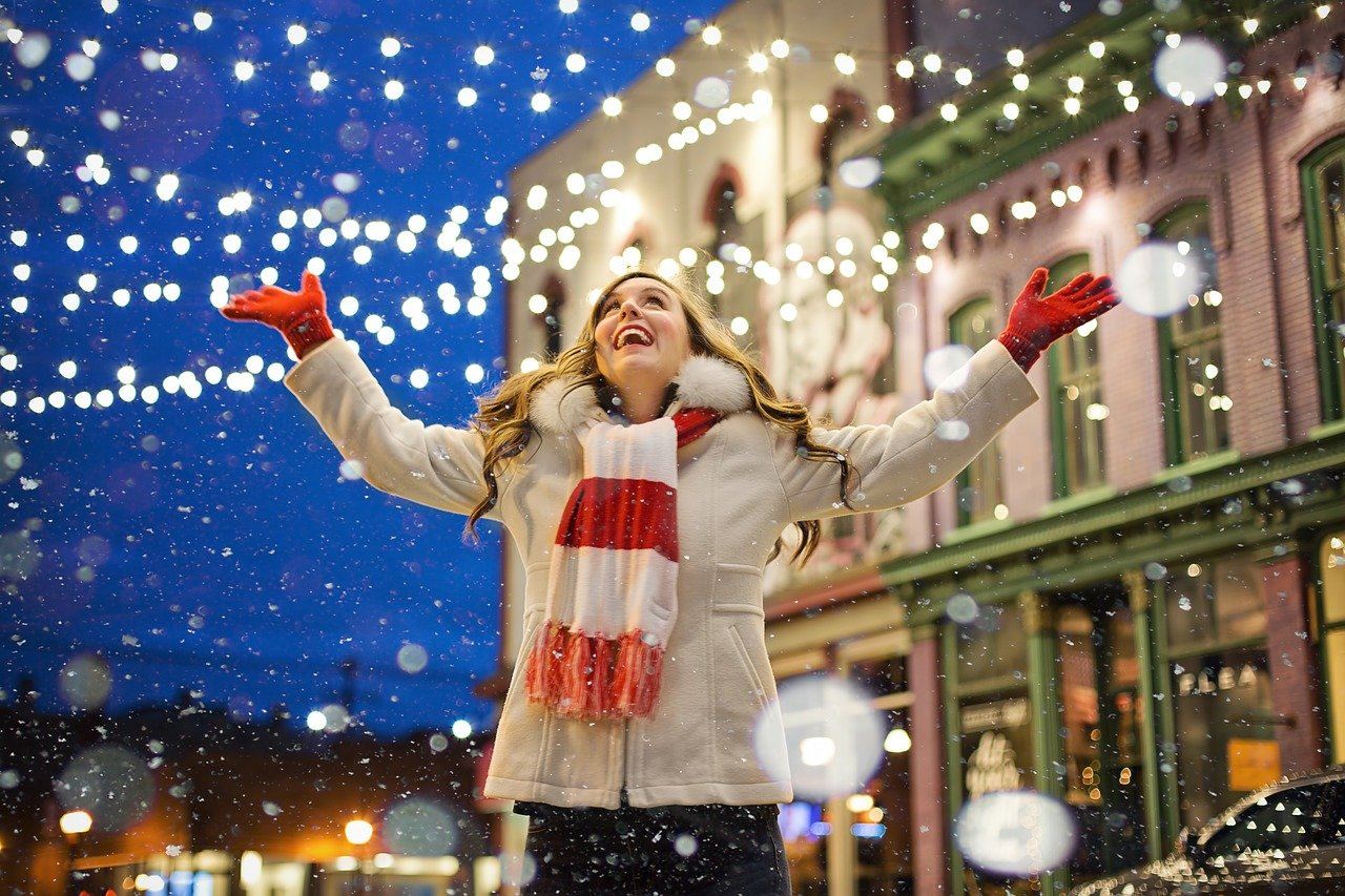 Women in snow fall embracing the holidays 