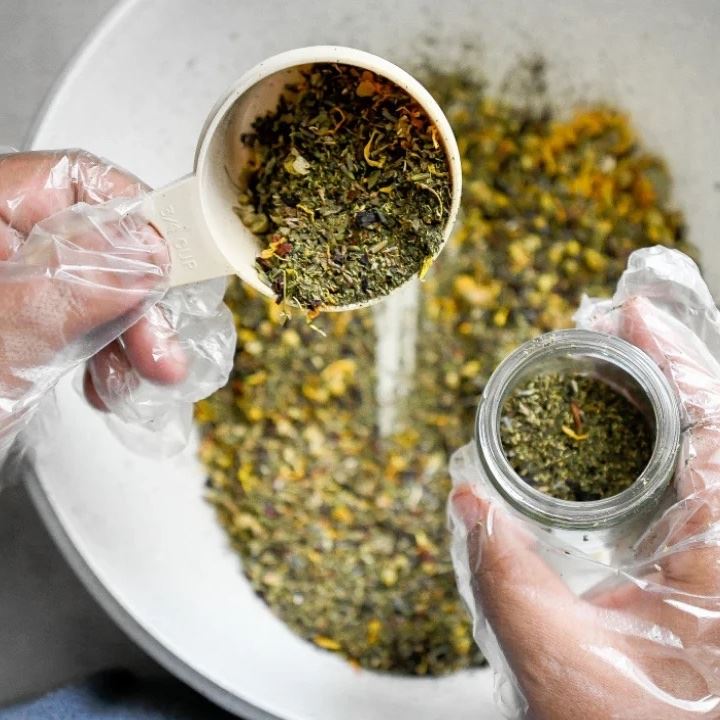 jasmine banks pouring herbs into a smaller container