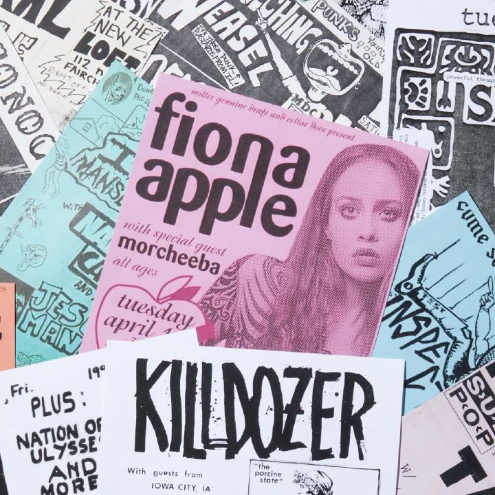 A Fiona Apple and Killdozer poster on top of other various gig posters by artists.