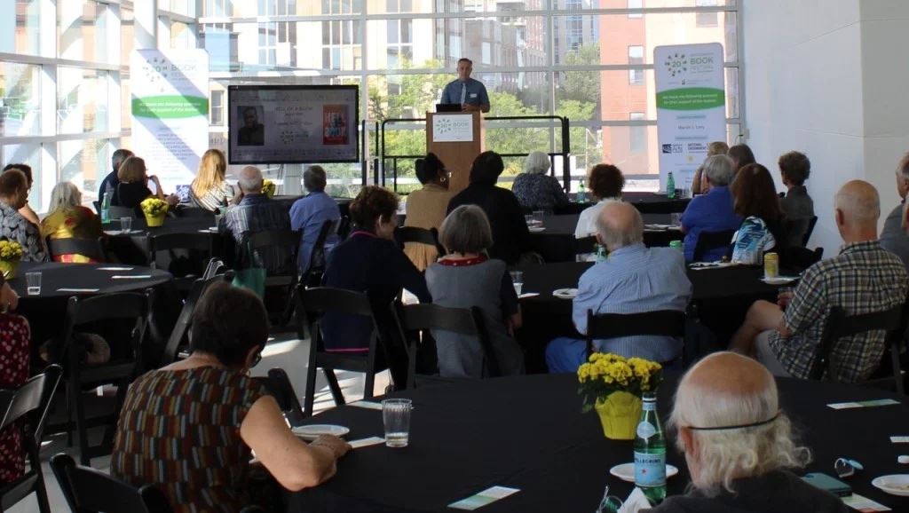 Festival members and sponsors listen to Wisconsin Book Festival director Conor Moran announce the 20th anniversary festival lineup at the library.