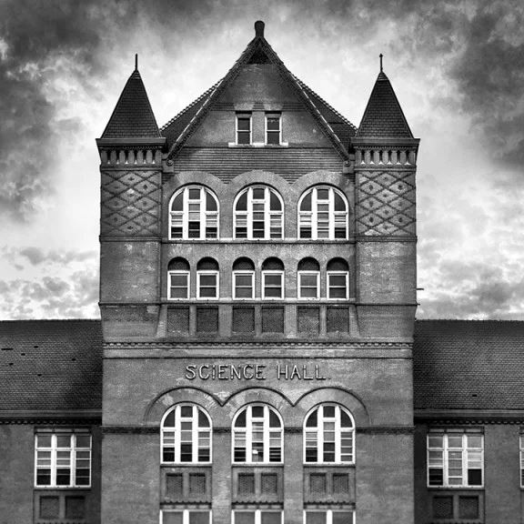 A creepy black and white photo of Science Hall, which looks like a haunted castle with dark clouds surrounding it