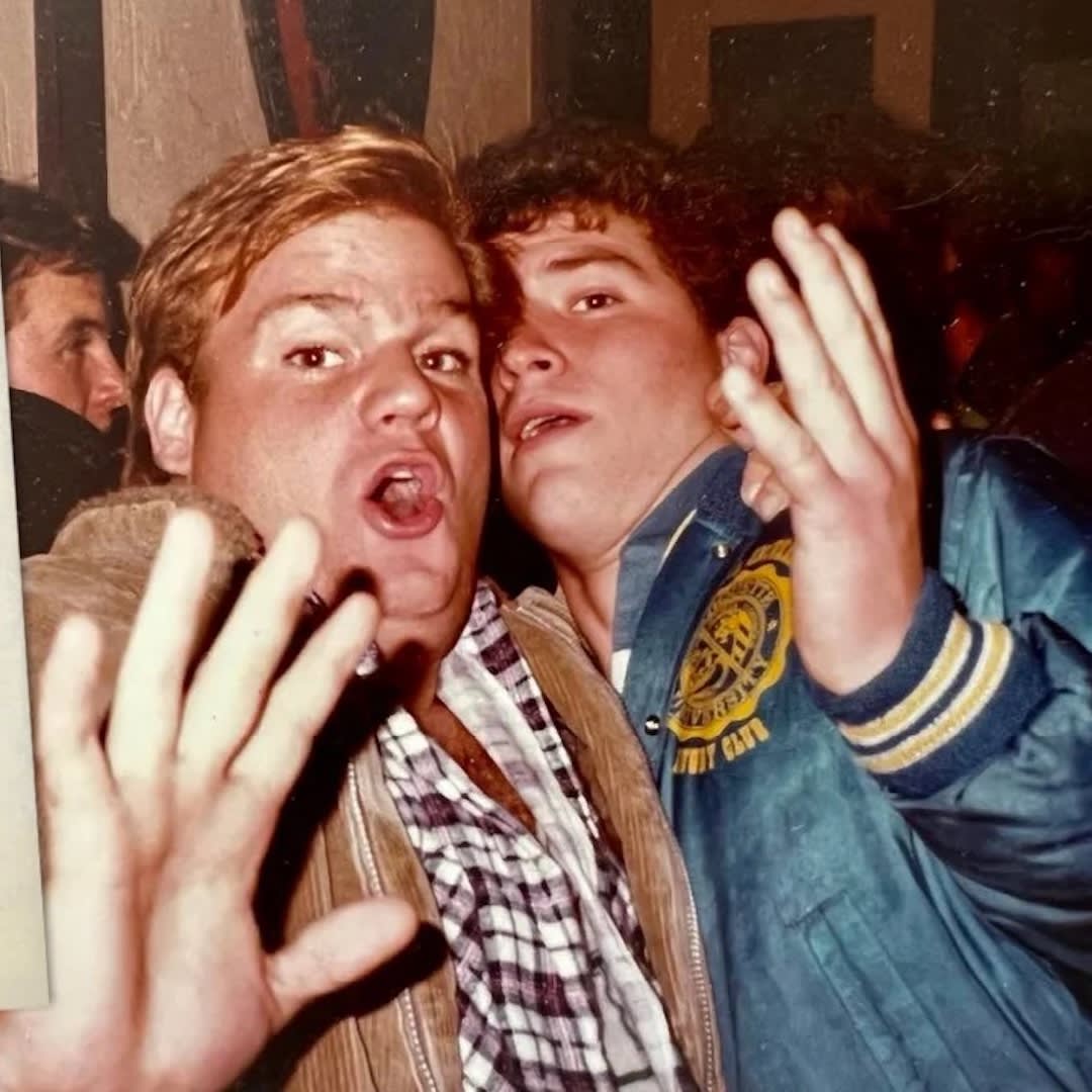 Young Chris Farley and Pat Fin holding their hands up and making faces at the camera.