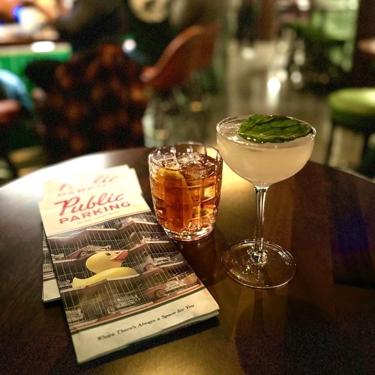 A photo of a drink and a table at Public Parking.