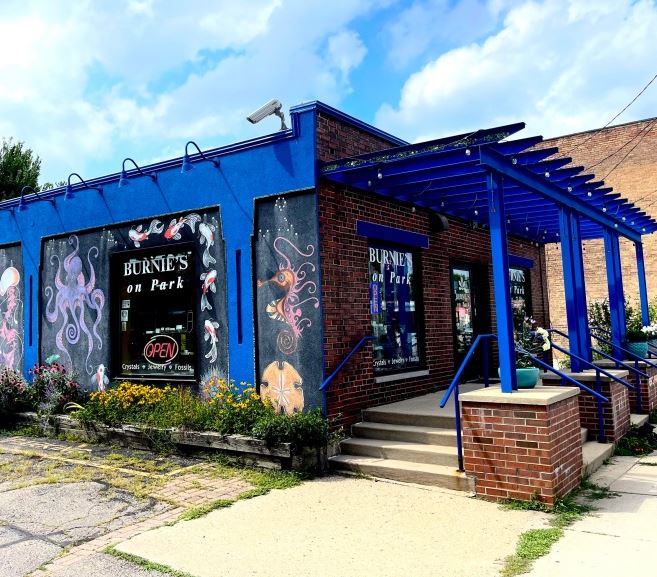 The exterior of Burnie's Rock Shop's Park Street location. It is royal blue and red brick, with illustrations of sea creatures on its side. 